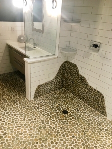Poolside curbless pebble tile bathroom
