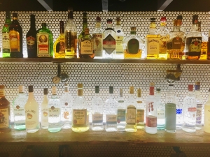 White penny tile with dove grey grout backdrop these reclaim planks lit by Tresco LED under-cabinet lighting supported by malleable pipe fitting, fitted with Trerice gauges.  Drink up!
