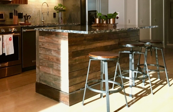 Reclaimed wood, custom-made, kitchen island with pebble print marble top. A rustic touch to a modern space